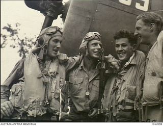 PIVA AIRFIELD, TOROKINA, BOUGAINVILLE ISLAND, SOLOMON ISLANDS. C. 1945-01-16. GROUP PORTRAIT OF FOUR KIWIS AND AUSSIES AFTER A COMBINED STRIKE AGAINST JAPANESE POSITIONS ON BOUGAINVILLE ISLAND. ..