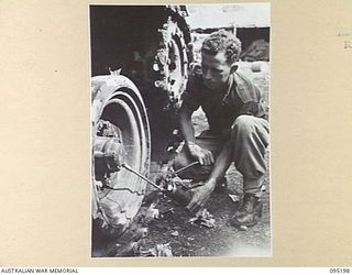 TOROKINA, BOUGAINVILLE, 1945-08-14. TROOPER C. BLATES GREASING THE SUSPENSION OF AN M24 LIGHT TANK DURING ACTIVITIES OF THE BRITISH WAR OFFICE TRIALS TEAM (TANKS)