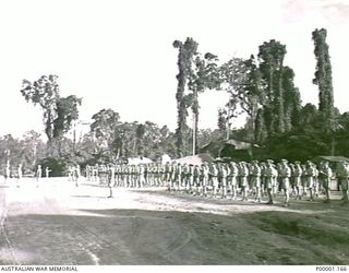 THE SOLOMON ISLANDS, 1945. NEW ZEALAND SERVICE PERSONNEL PRESENT ARMS AT A PARADE TO HONOUR AMERICAN MAJOR GENERAL R.J. MITCHELL ON THE OCCASION OF HIS DEPARTURE FROM BOUGAINVILLE ISLAND. (RNZAF ..