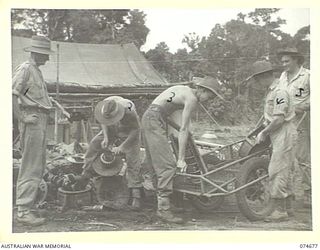 LAE-NADZAB, NEW GUINEA. 1944-07-25. TROOPS OF THE 8TH LINES OF COMMUNICATION SALVAGE DEPOT, SORTING OUT FERROUS AND NON-FERROUS METALS FROM OLD ENGINE PARTS AT THE UNIT HEADQUARTERS. IDENTIFIED ..