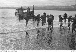 TAMIGUDU, NEW GUINEA. 1944-05-12. NATIVES ABOUT TO LOAD FRUIT AND VEGETABLES GROWN IN NATIVE GARDENS ON TO A BARGE. THE BARGE, CHARTERED FROM LAE BY THE AUSTRALIAN ARMY SERVICE CORPS, TRANSPORTS ..