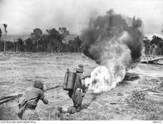 BOUGAINVILLE, SOLOMON ISLANDS. 1944-12-21. SERGEANT I.G. MCCOULLOUGH FIRING THE UNITED STATES FLAME THROWER M1A1 FROM THE KNEELING POSITION DURING A COURSE AT HEADQUARTERS 3 DIVISION ARRANGED BY ..