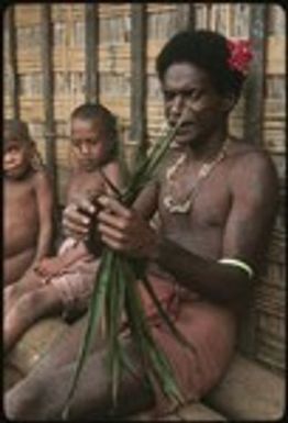 Man performing aringa divination as children look on