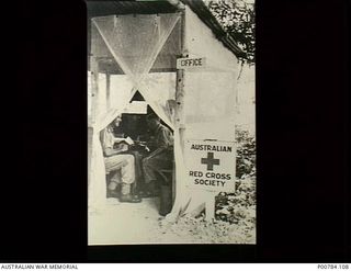 Heldsbach, Finschhafen, New Guinea. c. 1944. E.P. Heath and ? Aird, male representatives with the Australian Red Cross Society seated inside their screened office at the Heldsbach Mission. (This ..