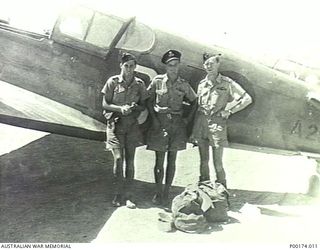 PROBABLY NEW GUINEA, C.1940-1942. FLYING OFFICER JOHN LE GAY BRERETON (LEFT) AND TWO OTHER RAAF OFFICERS BESIDE A P40 CURTISS KITTYHAWK AIRCRAFT