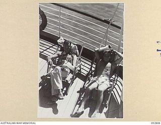 LAE, NEW GUINEA. 1945-06-09. PATIENTS FROM 2/7 GENERAL HOSPITAL GETTING THEIR SHARE OF SUNSHINE ON THE DECK OF THE HOSPITAL SHIP MANUNDA. IDENTIFIED PERSONNEL ARE:- CORPORAL K. BRAWN, 2/24 INFANTRY ..