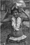 New mother wearing fiber skirt, shell belt, flower garland, skirt valuable on head, and paint on face