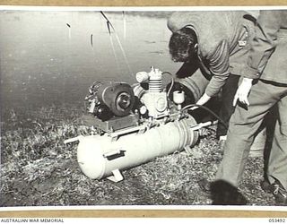 ASCOT RACECOURSE, SYDNEY, NSW. 1943-07-12. PERSONNEL OF THE HYGIENE SECTION OF THE NEW SOUTH WALES LINES OF COMMUNICATION AREA TESTS AN OUTFIT FOR SPRAYING SWAMPS AND PONDS IN NEW GUINEA, AND OTHER ..