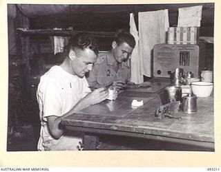 JACQUINOT BAY, NEW BRITAIN, 1945-06-16. WO 2 P.W. DALE (1) AND CPL E.C. BROOKER (2), DENTAL MECHANICS OF 77 DENTAL UNIT (AIF) AT WORK ON DENTURES