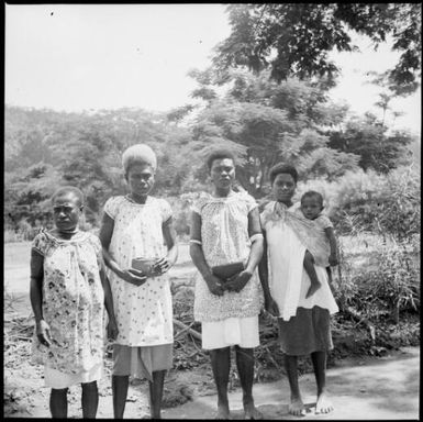 Four women, two holding packages and one holding a child, New Guinea, ca. 1936 / Sarah Chinnery