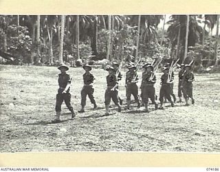 SIAR, NEW GUINEA. 1944-06-22. PERSONNEL OF COMPANY HEADQUARTERS, HEADQUARTERS COMPANY, 57/60TH INFANTRY BATTALION MOVING ACROSS THE UNIT PARADE GROUND AT THE CONCLUSION OF THE MORNING PARADE. ..