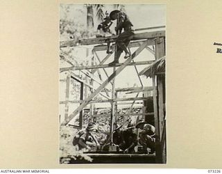 ALEXISHAFEN, NEW GUINEA. 1944-05. OFFICER'S BATMEN OF THE 2/15TH FIELD AMBULANCE WORKING ON THE CONSTRUCTION OF QUARTERS FOR THEIR OFFICERS AMONG THE BOMB DAMAGED BUILDINGS AT THE OLD CATHOLIC ..