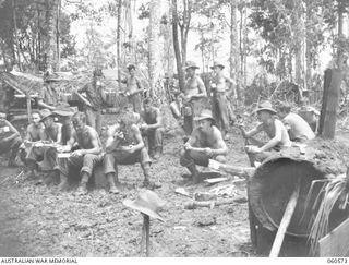 SATTELBERG AREA, NEW GUINEA. 1943-11-15. TROOPS OF THE 2/24TH. AUSTRALIAN INFANTRY BATTALION EATING MEAL DURING A LULL IN THE BATTLE FOR SATTELBERG. THEY ARE: NX10044 ACTING SERGEANT S. BOLDHAM. ..