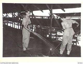 BOUGAINVILLE, 1945-04-18. PRIVATE H. PETTIT, (1), AND PRIVATE B.M. WEBB (2), AUSTRALIAN ARMY MEDICAL WOMEN'S SERVICE MEMBERS, CLEAN THE FLOOR OF THE MESS AT 2/1 GENERAL HOSPITAL