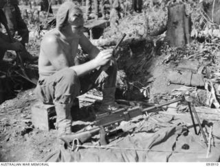 BOUGAINVILLE, 1945-07-14. PRIVATE N.A. BLUNDELL, D COMPANY, 15 INFANTRY BATTALION, CLEANING A JAPANESE 6.5MM TYPE 96 LIGHT MACHINE-GUN CAPTURED WHEN JAPANESE ATTACKED THE COMPANY POSITION WEST OF ..