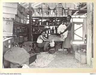 LABU, NEW GUINEA. 1944-12-18. PRIVATE R. FELSTEAD, (1), AMONG THE TECHNICAL STORES AT 55 PORT CRAFT COMPANY, PACKING STORES INTO THE BINS