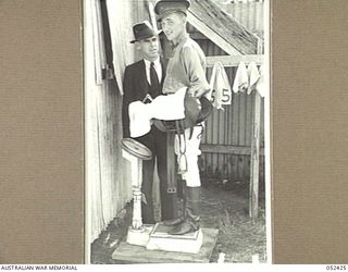 HERBERTON, QLD. 1943-06-12. VX29453 PRIVATE D. MORGAN WEIGHS OUT FOR THE SECOND RACE AT THE 6TH AUSTRALIAN DIVISION RACE MEETING, WHILE THE PRESIDENT OF THE HERBERTON HACK CLUB, MR. HOLCROFT, LOOKS ..