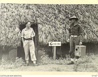 PORT MORESBY, PAPUA, NEW GUINEA. 1944-03-08. VX117041 LIEUTENANT F.D. DANGLOW (1) AND VX63473 SERGEANT A.E. BURT (2) OUTSIDE THE OFFICE OF "G" VISUAL TRAINING CENTRE, HEADQUARTERS, NEW GUINEA FORCE