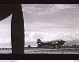 LAE, NEW GUINEA. 1043-10-11. DOUGLAS TRANSPORT AIRCRAFT LANDING ON THE AIRSTRIP