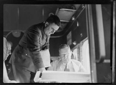 Sir Harvey Luke and unidentified man in the cabin of the seaplane Aotearoa in Suva