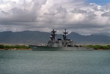 The destroyer USS HARRY W. HILL (DD-986) departs from the naval station after a port visit.
