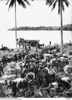 New Guinea, Finschhafen area, 1943-10-30. A transport company stack stores which were dumped during the night at a spot near scarlet beach. Recently three Japanese barges landed at Scarlet Beach, ..