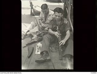 AT SEA OFF AITAPE, NORTH EAST NEW GUINEA. C. 1944-04. PREPARING FOR ALL EVENTUALITIES TWO MEMBERS OF THE RAAF, FLIGHT LIEUTENANT T. C. MCKALE, BONDI, NSW AND PILOT OFFICER A. E. WELBOURN, NEUTRAL ..