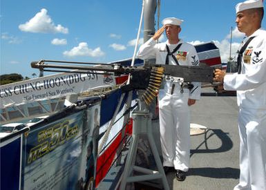 US Navy (USN) Sailors assigned aboard the Arleigh Burke Class (Flight IIA): Guided Missile Destroyer (Aegis), USS CHUNG-HOON (DDG 93), prepare to render a salute using the.50 Caliber M2 machine gun (equipped with a blank firing device) during the ships official Commissioning Ceremony, held at Pearl Harbor, Hawaii (HI)