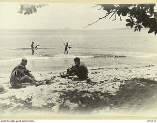 KOMANA POINT, NEW GUINEA. 1944-07-30. PERSONNEL OF D COMPANY, 30TH INFANTRY BATTALION ENJOY SOME FISHING ON THE BEACH DURING ONE OF THEIR STAND DOWN PERIODS. IDENTIFIED PERSONNEL ARE:- NX125987 ..