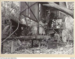 SORAKEN AREA, BOUGAINVILLE. 1945-04-02. GUNNER J. HARLEY (1), AND SERGEANT D.W. JACK (2); MEMBERS OF THE 4 MILITARY HISTORY FIELD TEAM LOOK FOR ANYTHING OF VALUE IN AN ABANDONED JAPANESE POSITION. ..