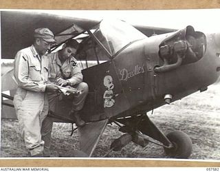 KAIAPIT, NEW GUINEA. 1943-09-24. LIEUTENANT COLONEL W.V. KING, UNITED STATES MALARIAL CONTROL OFFICER (LEFT) AND CAPTAIN EUGENE V. STRAW, UNITED STATES 2 AIR TASK FORCE OFFICER (RIGHT) PREPARING TO ..