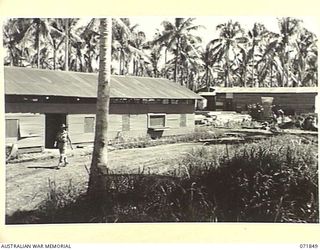 LAE, NEW GUINEA. 1944-03-29. THE 5,000 FEET FREEZER AT THE 39TH SUPPLY DEPOT COMPANY IS SITUATED IN THE EXTREME BACKGROUND. THE STACKED TIMBER IS BEING USED IN THE CONSTRUCTION OF A 20,000 CUBIC ..