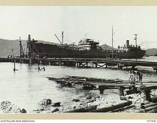 MILNE BAY, PAPUA, NEW GUINEA. 1944-04-03. THE DEEP SEA TANKER 'EMPIRE SILVER', WITH A CAPACITY OF 3,600,000 IMPERIAL GALLONS DISCHARGING A CARGO OF PETROL FROM THE OIL WHARF. THE FUEL IS PUMPED ..