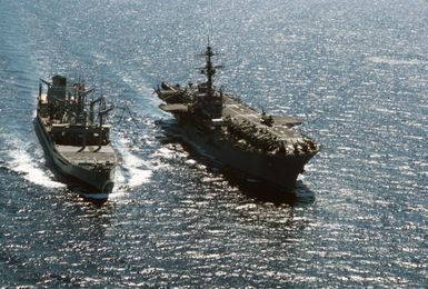 An aerial bow view of the fleet oiler USNS WACCAMAW (T-AO 109) underway alongside the amphibious assault ship USS GUAM (LPH 9) during an underway replenishment