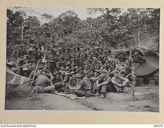 WONGINARA MISSION, NEW GUINEA. 1945-04-07. MOST OF THE MEMBERS OF "A" COMPANY, 2/3 INFANTRY BATTALION GROUPED AROUND A CARD GAME