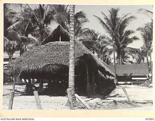 JACQUINOT BAY, NEW BRITAIN. 1945-06-09. A WARD AT 2/8 GENERAL HOSPITAL IN 5 BASE SUB-AREA. IT IS NATIVE BUILT AND THATCHED, WITH AN ARMY BUILT KITCHEN AND WARD OFFICE IN THE CENTRE