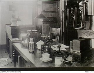 Fanning Island. 7 September 1914. Part of the interior of the office of the Pacific Cable Board on Fanning Island showing a badly damaged condenser box, cable recorder and test board. German ..