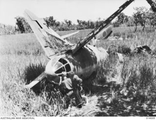 1943-01-08. PAPUA. BUNA. EVIDENCE OF THE ACCURACY OF ALLIED AIRMEN WHEN THEY BOMBED THE AIR STRIP AT BUNA IS THIS WRECKED JAPANESE BOMBER ON THE LANDING STRIP. (NEGATIVE BY G. SILK)