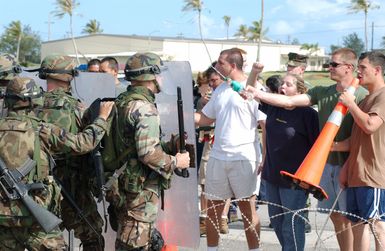 US Marine Corps (USMC) Marines from 2nd Battalion, 11th Marine Regiment, Marine Corps Base (MCB) Camp Pendleton, California (CA), conduct a riot control exercise stopping access to a restricted area during a simulated non-combatant evacuation operation (NEO) at the US Naval Forces Marianas Support Activity, Guam, during Exercise TANDEM THRUST 2003