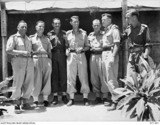 PORT MORESBY, PAPUA, 1944-03-21. OFFICERS OF THE 2/102ND GENERAL TRANSPORT COMPANY PICTURED OUTSIDE THEIR MESS HUT. IDENTIFIED PERSONNEL ARE: NX27310 LIEUTENANT K.G. CAMPBELL (1); N53447 LIEUTENANT ..