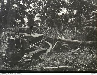 NADZAB, NEW GUINEA. C. 1944-02. JUNGLE TREES BEING PUSHED ASIDE BY A BULLDOZER OF NO. 62 MOBILE WORKS SQUADRON RAAF. MODERN CLEARING AND EARTHMOVING MACHINERY HAS MADE POSSIBLE THE RAPID EXPANSION ..