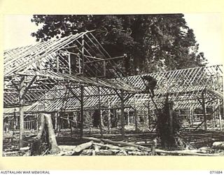LAE, NEW GUINEA. 1944-03-25. NATIVES FROM THE AUSTRALIAN NEW GUINEA ADMINISTRATIVE UNIT NATIVE LABOUR COMPOUND BUILD THE MENS' QUARTERS AT HEADQUARTERS LAE BASE SUB-AREA