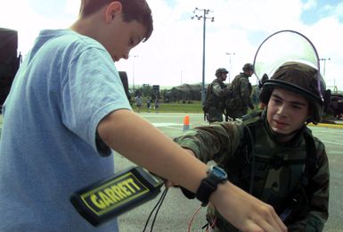 Sergeant (SGT) Jason Fournier, 2nd Battalion, 11th Marine Regiment scans a role player for concealed contraband prior to escorting him to the Entry Control Point (ECP) during a simulated Noncombatant Evacuation Operation (NEO), in support of Exercise TANDEM THRUST 2003