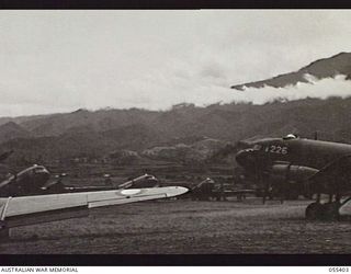 WAU, NEW GUINEA. 1943-08-08. DOUGLAS C47 DAKOTA AIRCRAFT LINED UP ON THE AIRFIELD