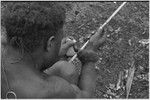 Carving: stone tool being used to smooth an arrow