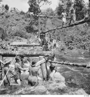 1942-11-19. NEW GUINEA. KOKODA. ENGINEERS BUILDING A BRIDGE - ONE OF THE MANY THAT WILL BE NECESSARY ALONG THE TRACK FROM KOKODA TO BUNA