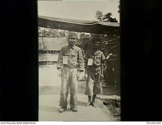 Torokina, Bougainville, New Guinea. 1945-09. Two Japanese prisoners of war outside a tent at the 2/1st Australian General Hospital (2/1AGH). Sick and starving soldiers like these continued to ..