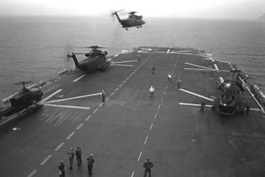 An H-53 Sea Stallion helicopter lifts off the flight deck of the amphibious assault ship USS SAIPAN (LHA-2) during the NATO exercise Display Determination '81. The other helicopters are from left to right: an AH-1 Sea Cobra, an H-53 Sea Stallion and an H-46 Sea Knight