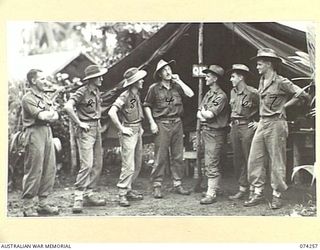 SIAR, NEW GUINEA. 1944-06-23. PERSONNEL OF THE 57/60TH INFANTRY BATTALION ENJOY A YARN IN FRONT OF THE UNIT Q STORE. IDENTIFIED PERSONNEL ARE:- VX141661 PRIVATE A. DELAHUNTY (1); V300601 PRIVATE ..