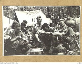 GEYTON'S POST, NEW GUINEA. 1944-01-19/20. PERSONNEL OF THE 2/5TH FIELD AMBULANCE HAVING LUNCH AT THEIR NEW ADVANCED DRESSING STATION AT GEYTON'S POST. IDENTIFIED PERSONNEL ARE:- VX11525 STAFF ..